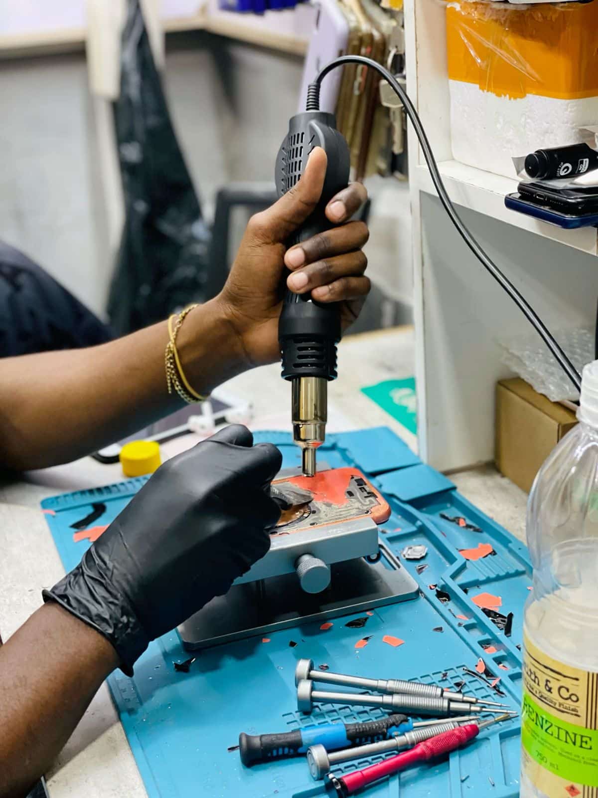 Technician performing iPhone screen repair on a clean workbench in Ocala