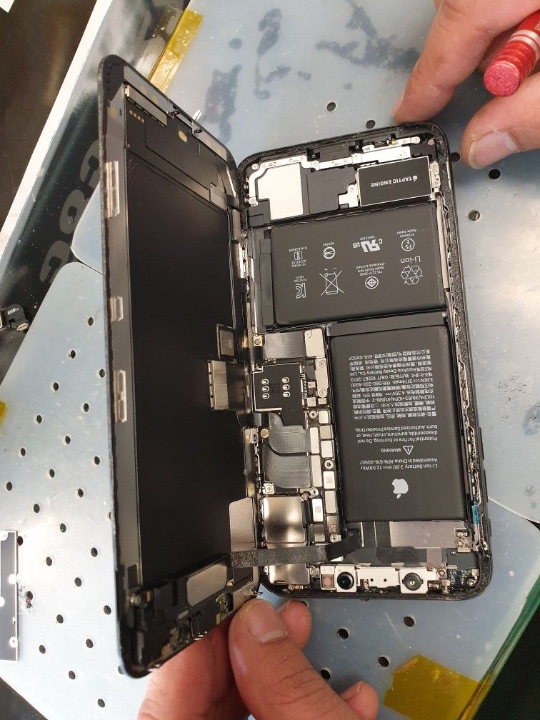 Technician inspecting a wet iPhone for liquid damage in Ocala